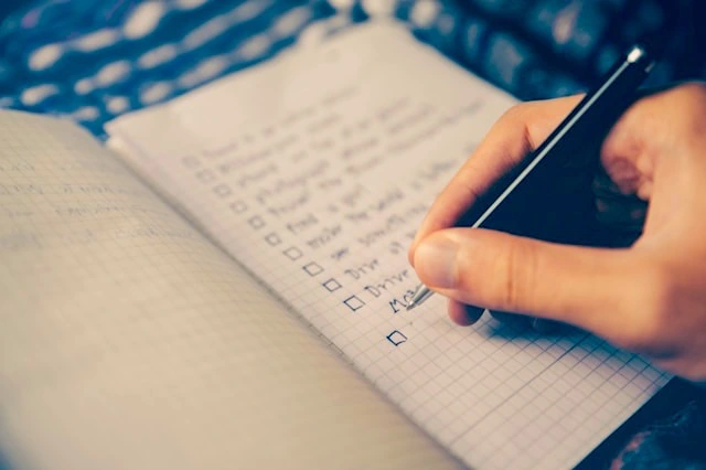 10 Essential Wedding Planning Tips for a Stress-Free Big Day | Take A Vow Stories a person writing wedding tasks on a notebook
