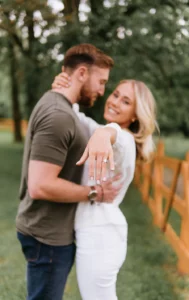 Couple hugging and girl shows a diamond on her finger